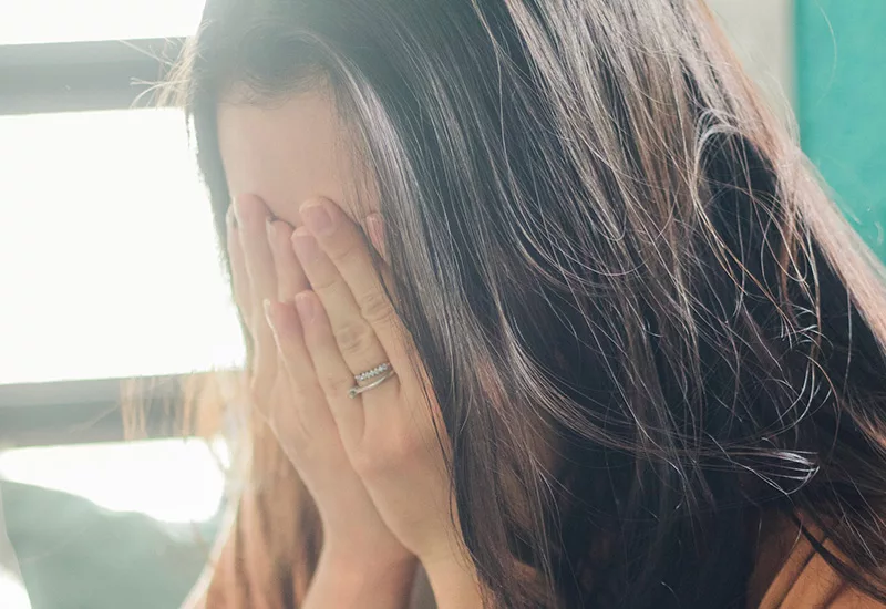 Femme le visage dans les mains
